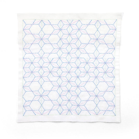 a white fabric with a repeating pattern of blue and pink hexagons.