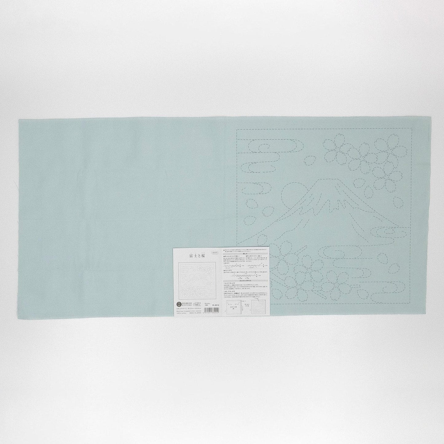 The image is a light blue fabric with a white label attached to it, which appears to be a sewing pattern or instructions.