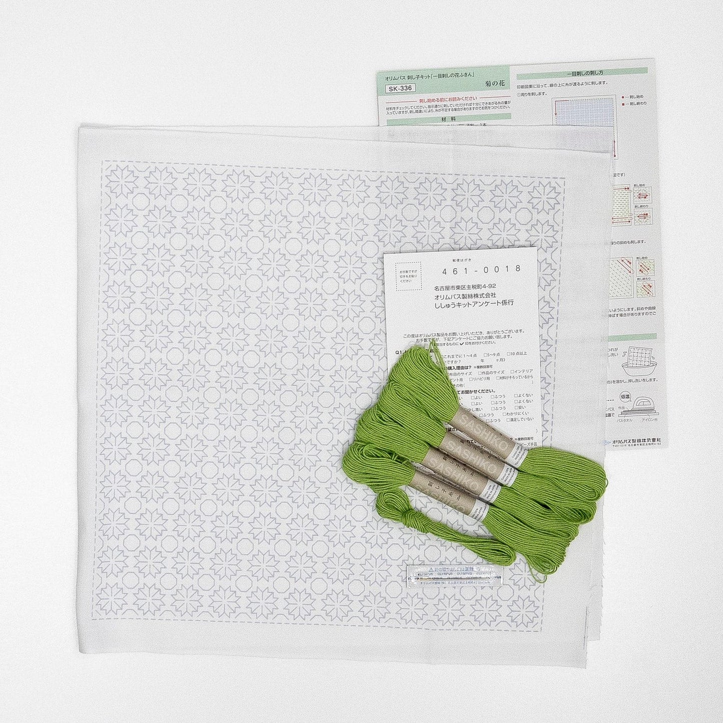 a sewing kit with a pattern, green thread, and a booklet with instructions or information about the kit.