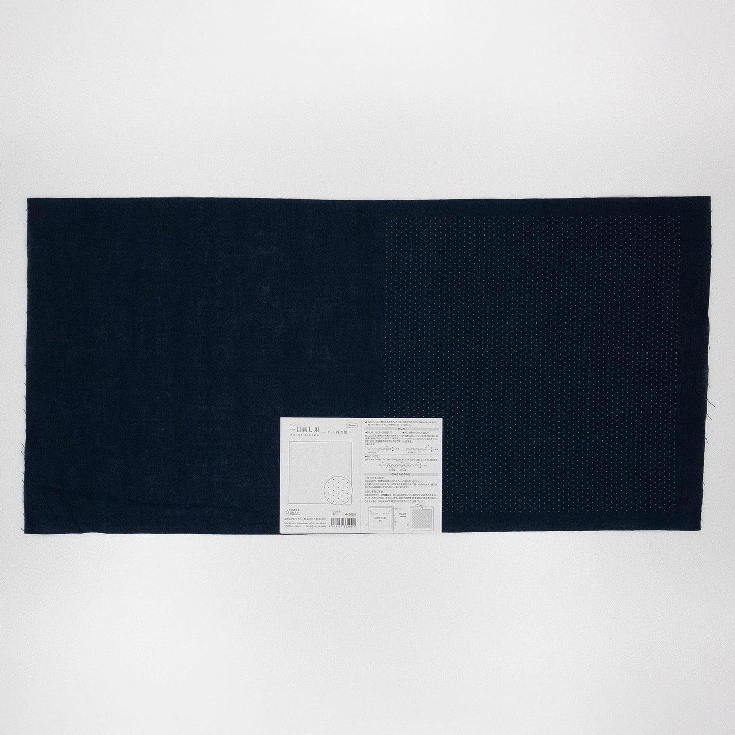 The image is a black fabric with a white label attached to it, placed against a white background.