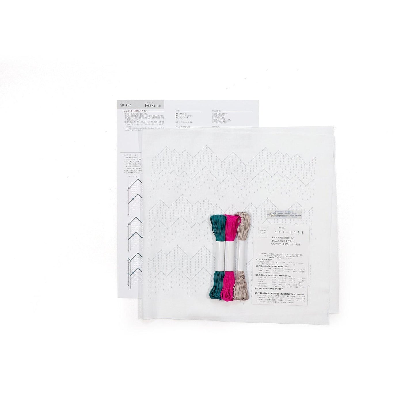 a sewing kit with various items, including a piece of paper with instructions and a spool of thread.