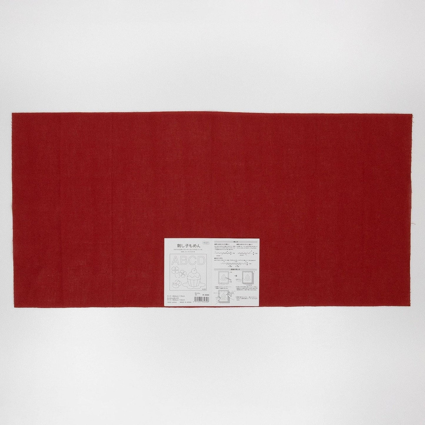 The image is a large red fabric or cloth with a white label or tag attached to it, which appears to be a product or packaging.