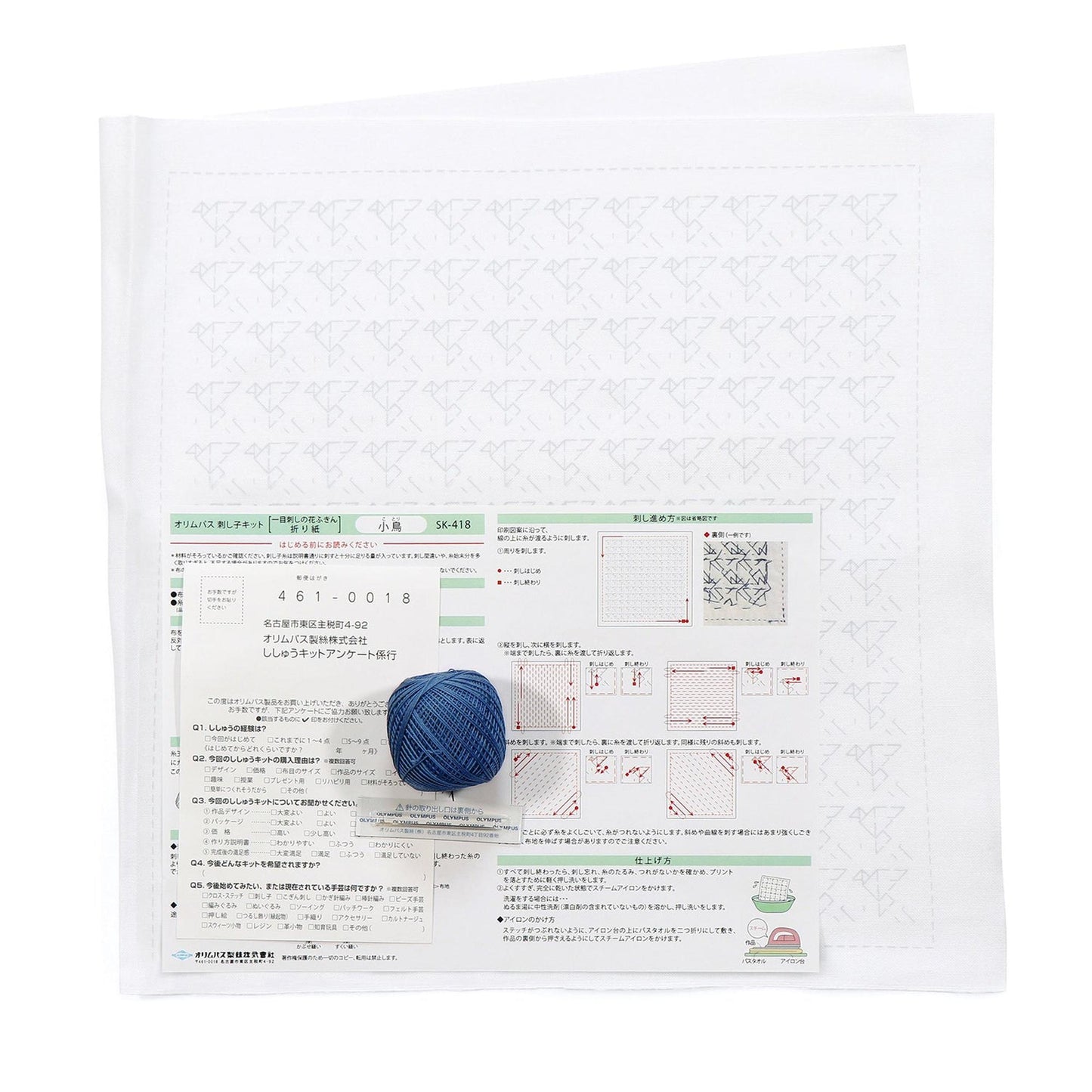 a printed document with various text and diagrams, along with a ball of yarn and a crochet hook. The document appears to be a technical or instructional document related to crochet or knitting, with some text and diagrams in Japanese.