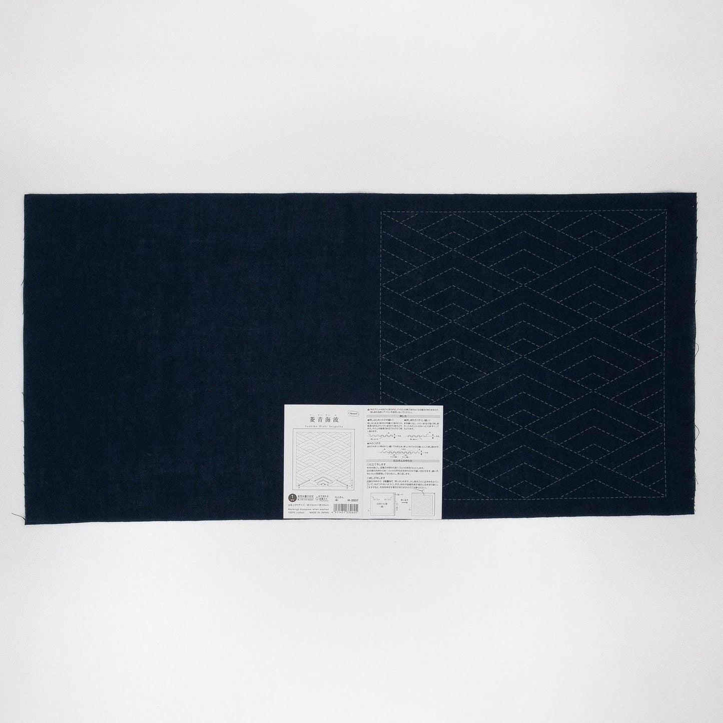 The image is a dark blue fabric with a white label attached to it, which appears to be a piece of paper with text and diagrams.