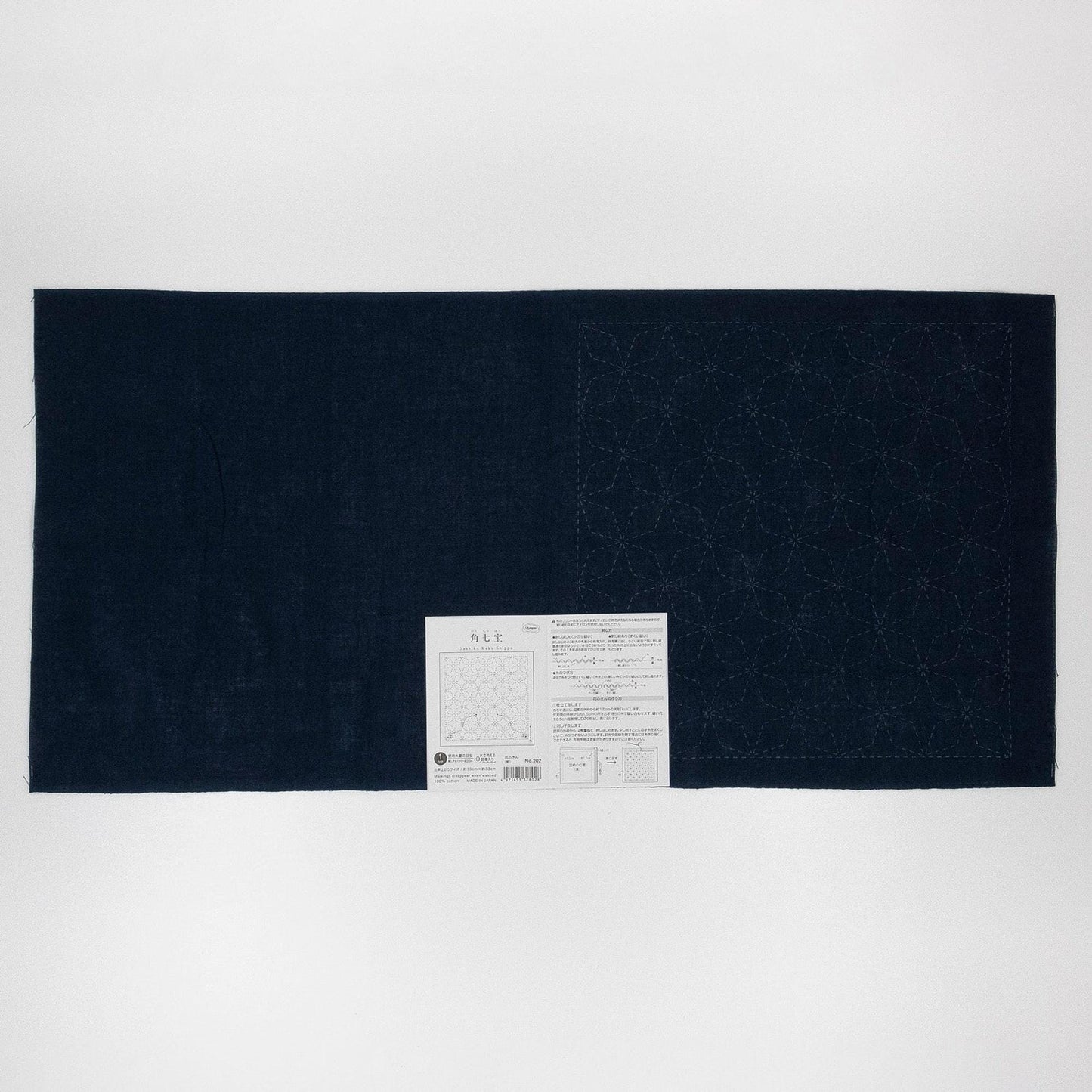 The image is a black fabric with a white label attached to it, which appears to be a piece of paper with text and a diagram.