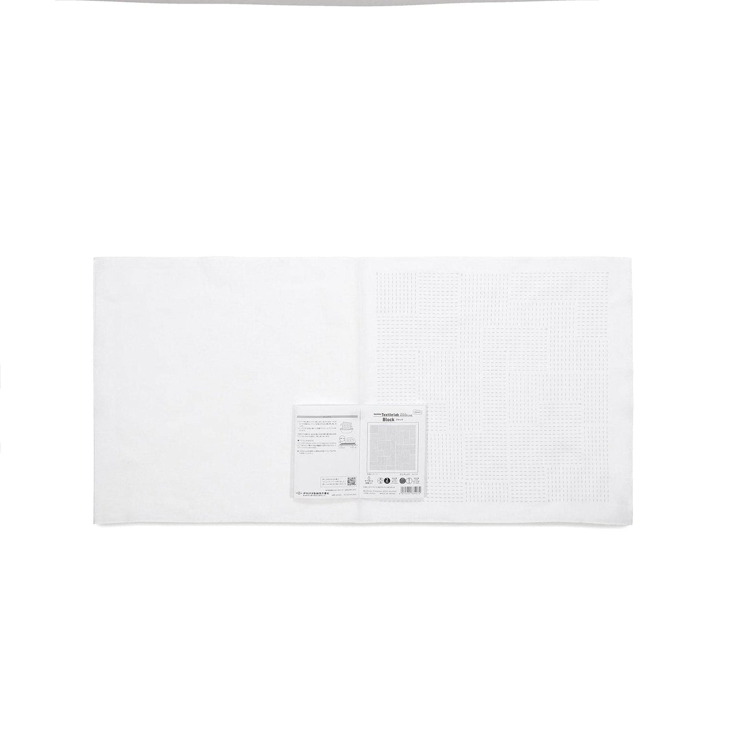 The image is a plain white sheet of paper or fabric with a small label or tag attached to it.
