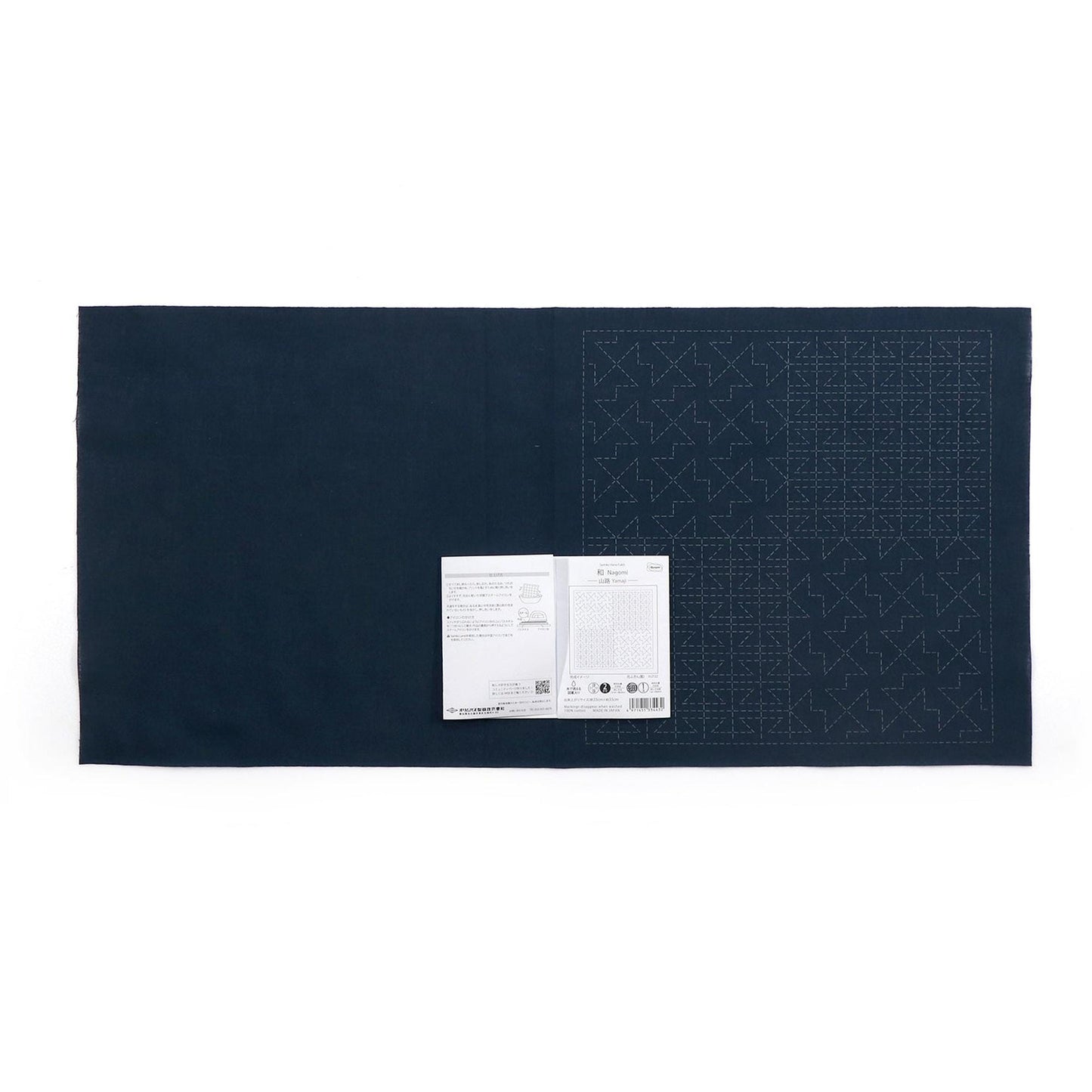 The image is a dark blue fabric with a white paper attached to it, displaying a grid pattern.