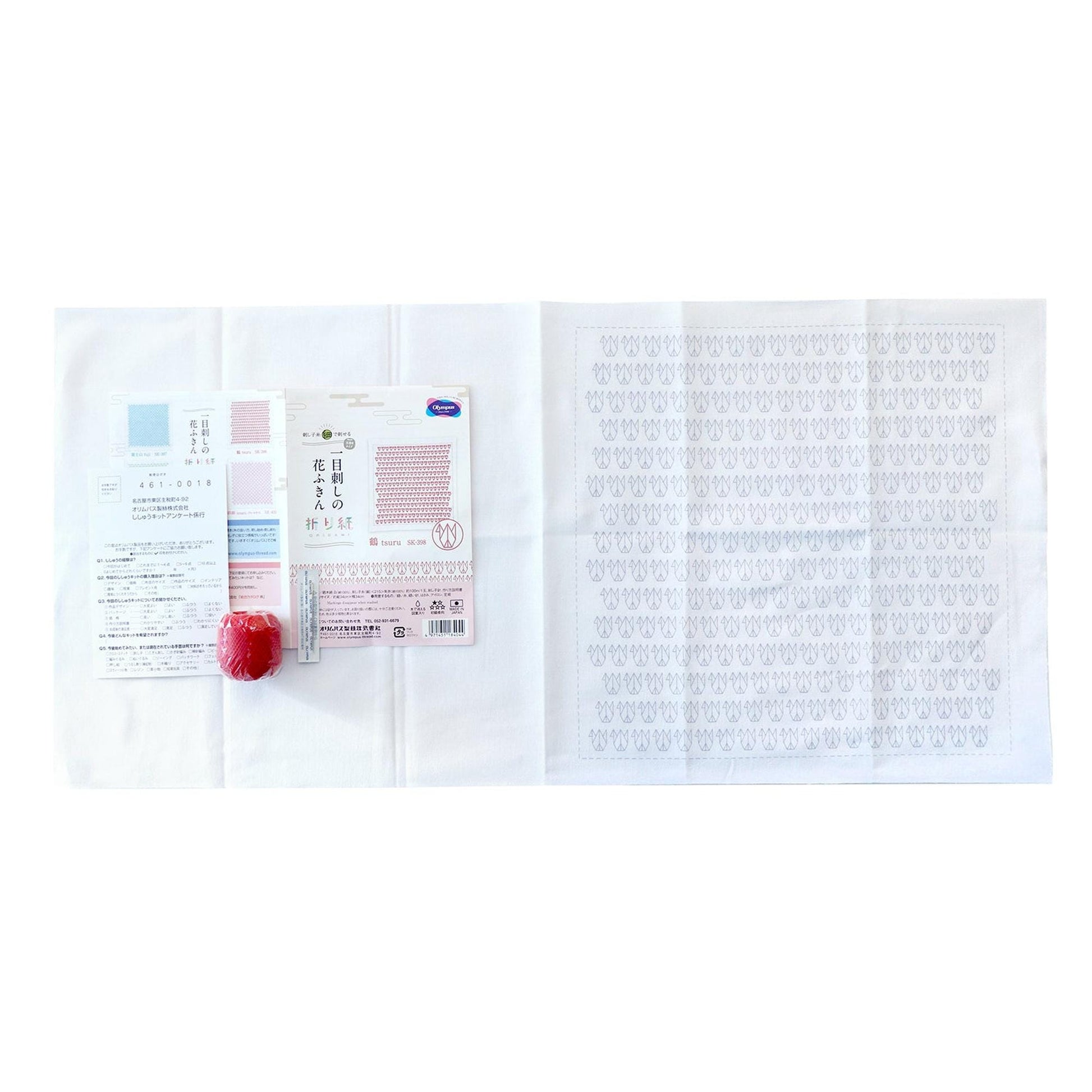 a white cloth with a red apple and some text printed on it, along with a small red object.