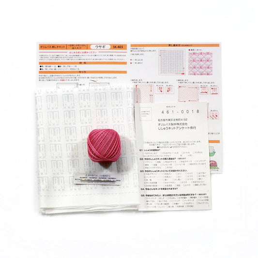 various knitting supplies, including a ball of yarn, a pattern, and some instructions or information.