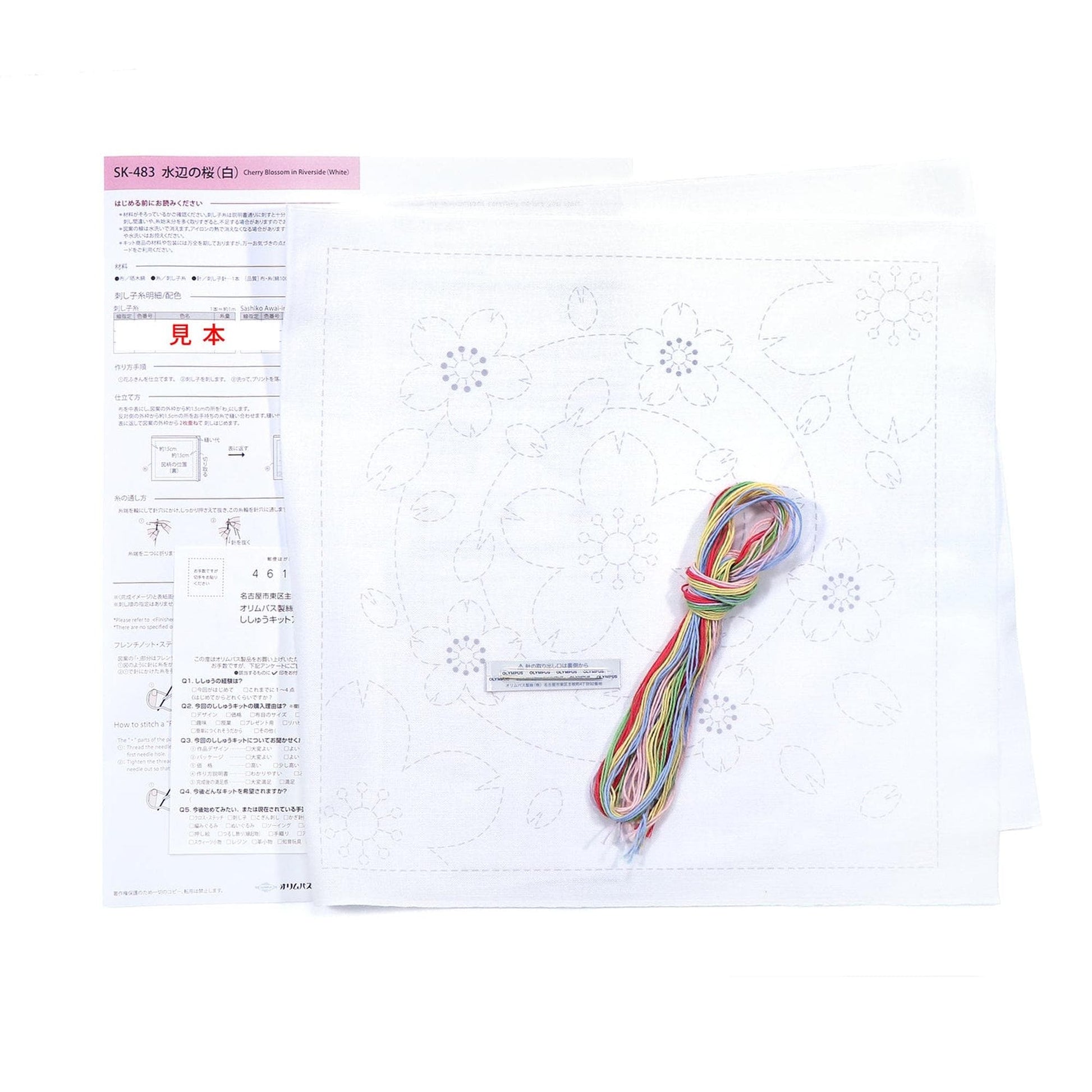 a sewing kit with instructions and a spool of multicolored thread, along with a piece of paper with instructions and a diagram.