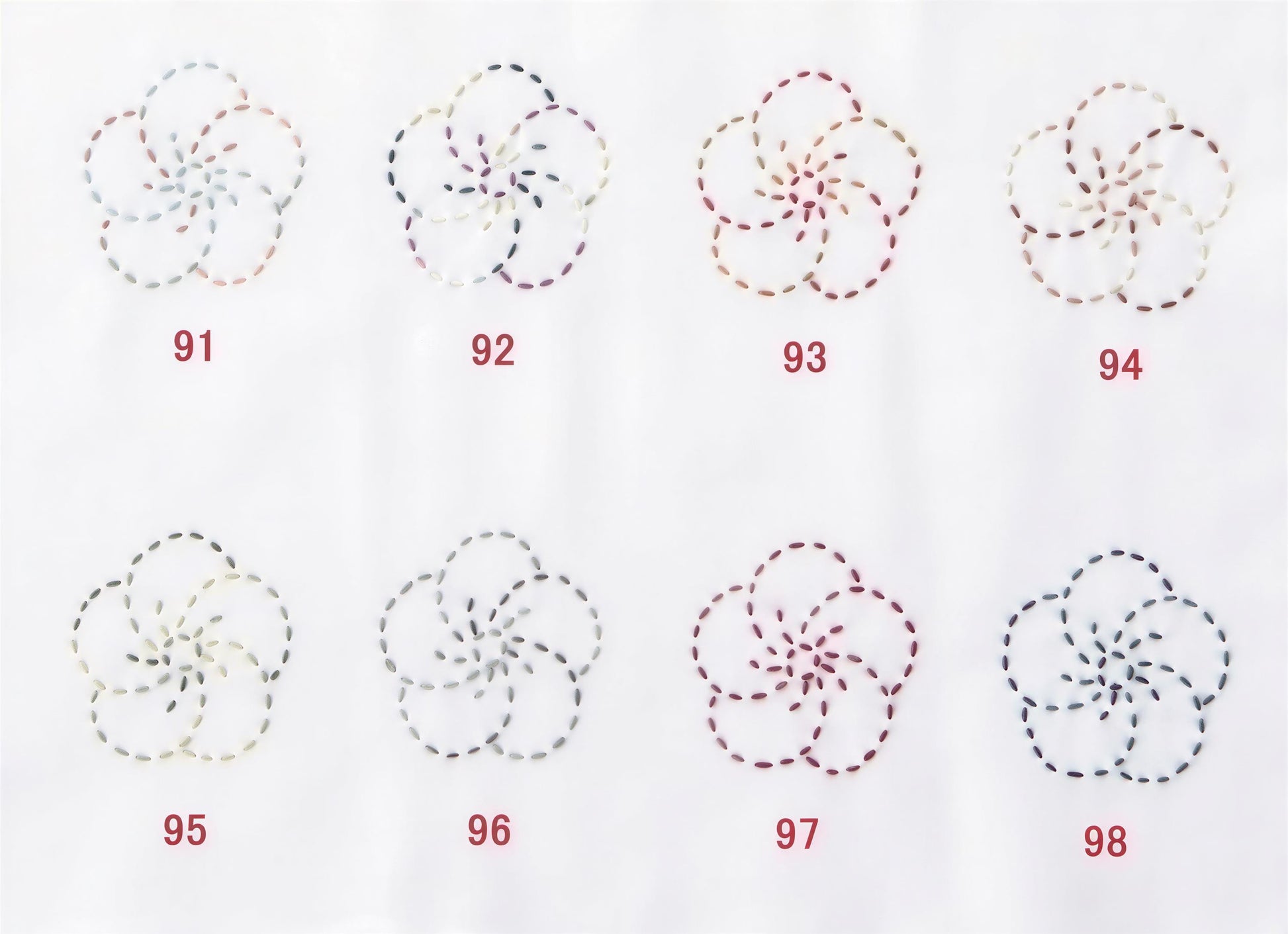 a collection of eight flower-like patterns, each with a unique color and design, arranged in a grid format.