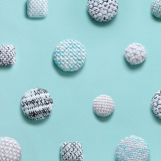 a collection of variously shaped and sized balls, including round and square ones, arranged on a light blue background.