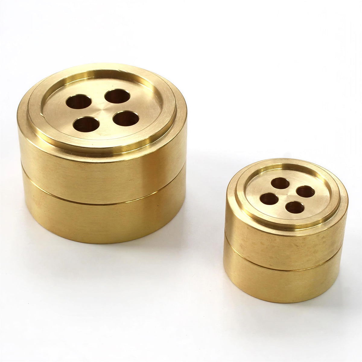 two golden-colored metal objects with a circular design, possibly resembling buttons or similar fasteners.