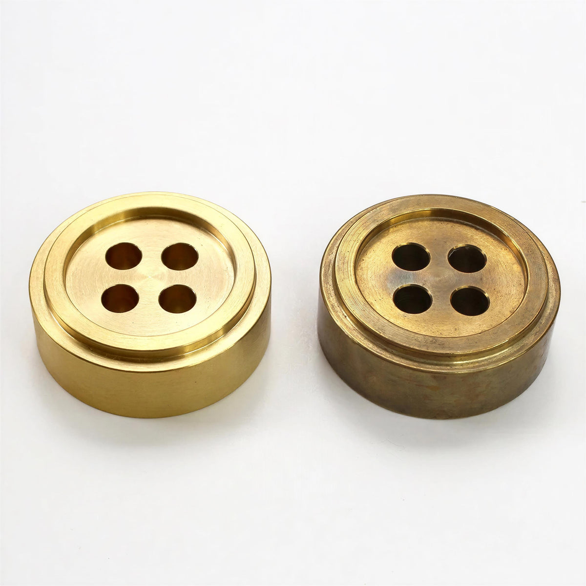 two metal objects, one brass and one brass, with a button-like design.