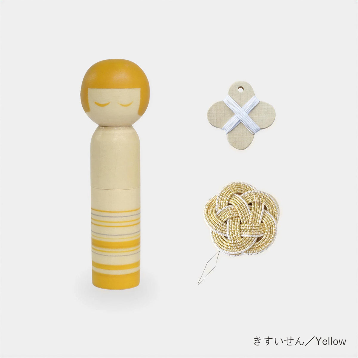 a wooden doll with a yellow body and striped pattern, a white cross-shaped object, and a knotted yellow object.