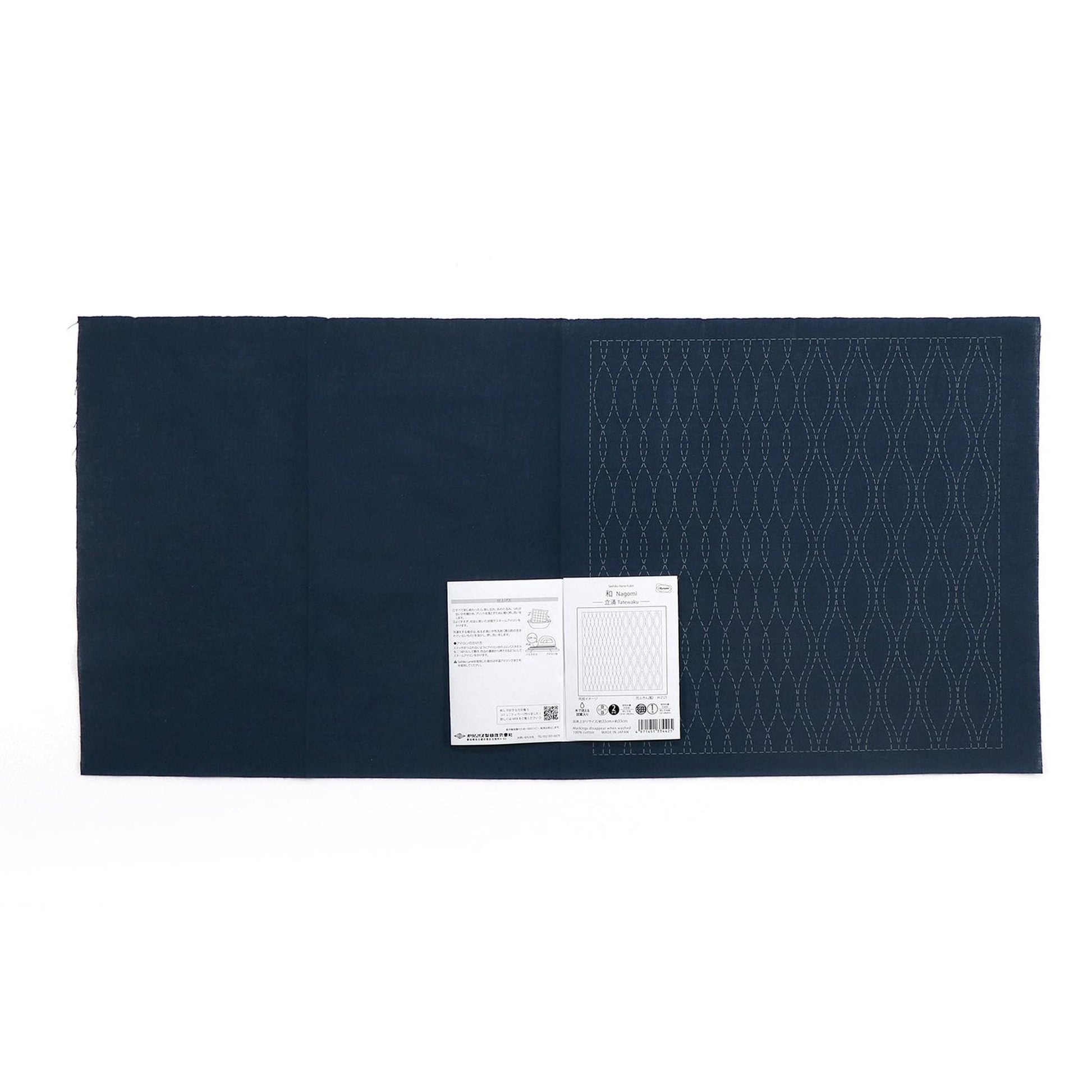 The image is a dark blue fabric with a white label attached to it, which appears to be a piece of paper or a printed document.