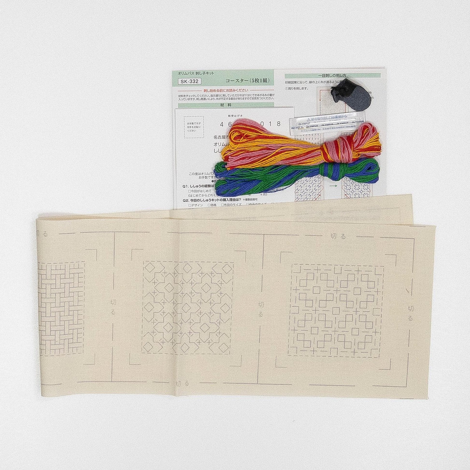 a sewing kit with various items, including a piece of paper with instructions and a spool of thread.