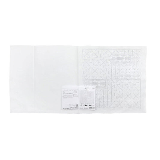 The image is a white sheet of paper with a grid pattern on it, and there is a small piece of paper with text next to it.