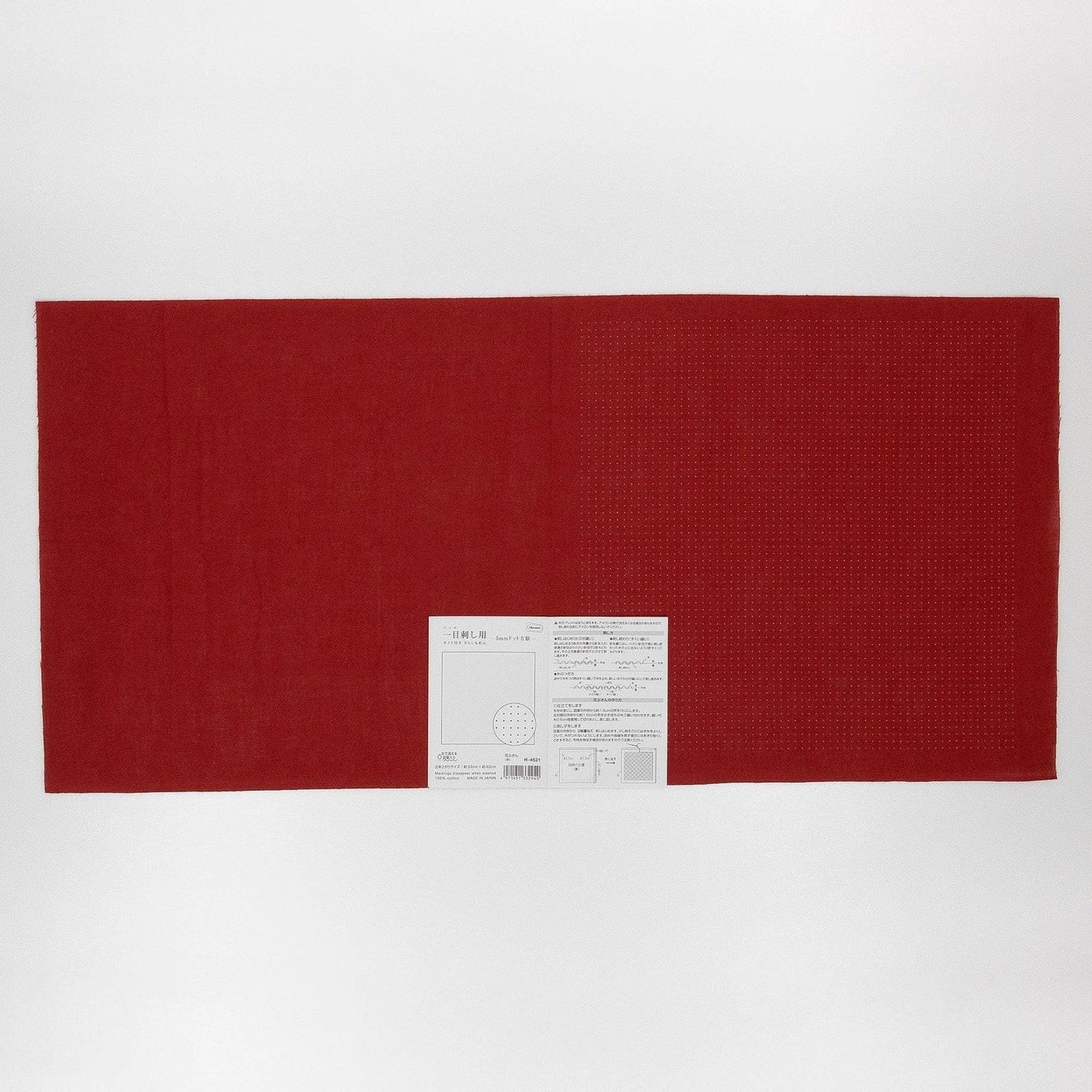 The image is a red fabric with a white label attached to it, placed against a white background.