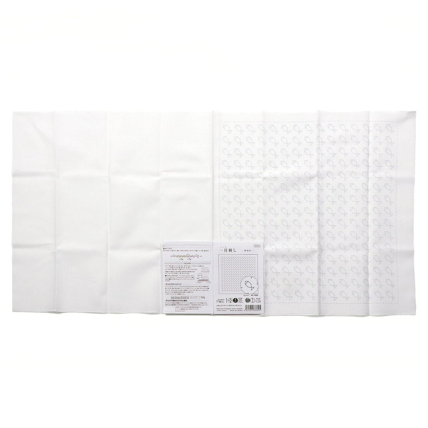 The image is a white cloth with a pattern of stars on it, and there is a small piece of paper with text next to it.