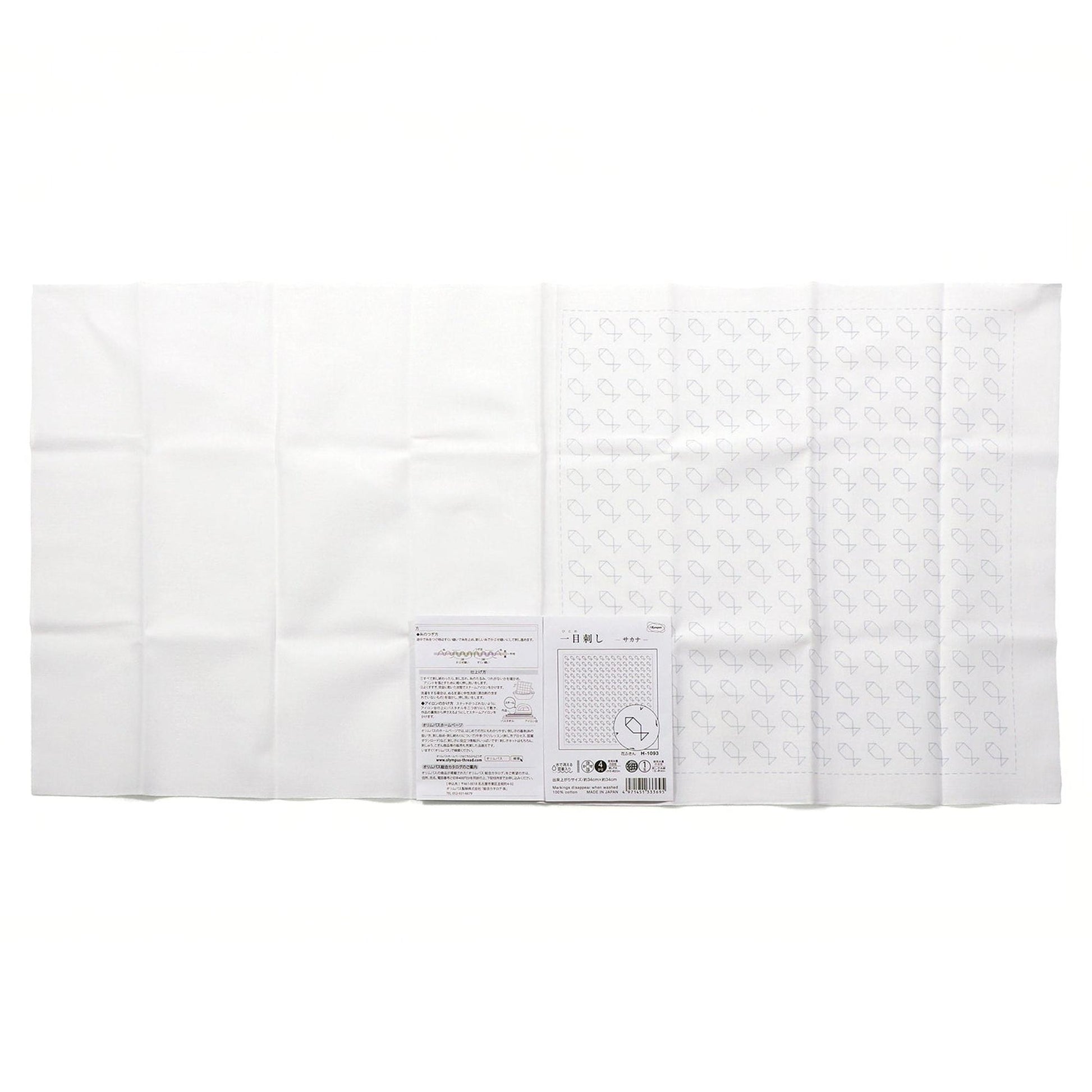 The image is a white cloth with a pattern of stars on it, and there is a small piece of paper with text next to it.