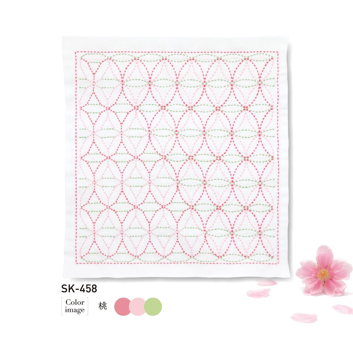 a square piece of fabric with a repeating pattern of pink and green circles, along with a single pink flower and some pink petals on the right side.