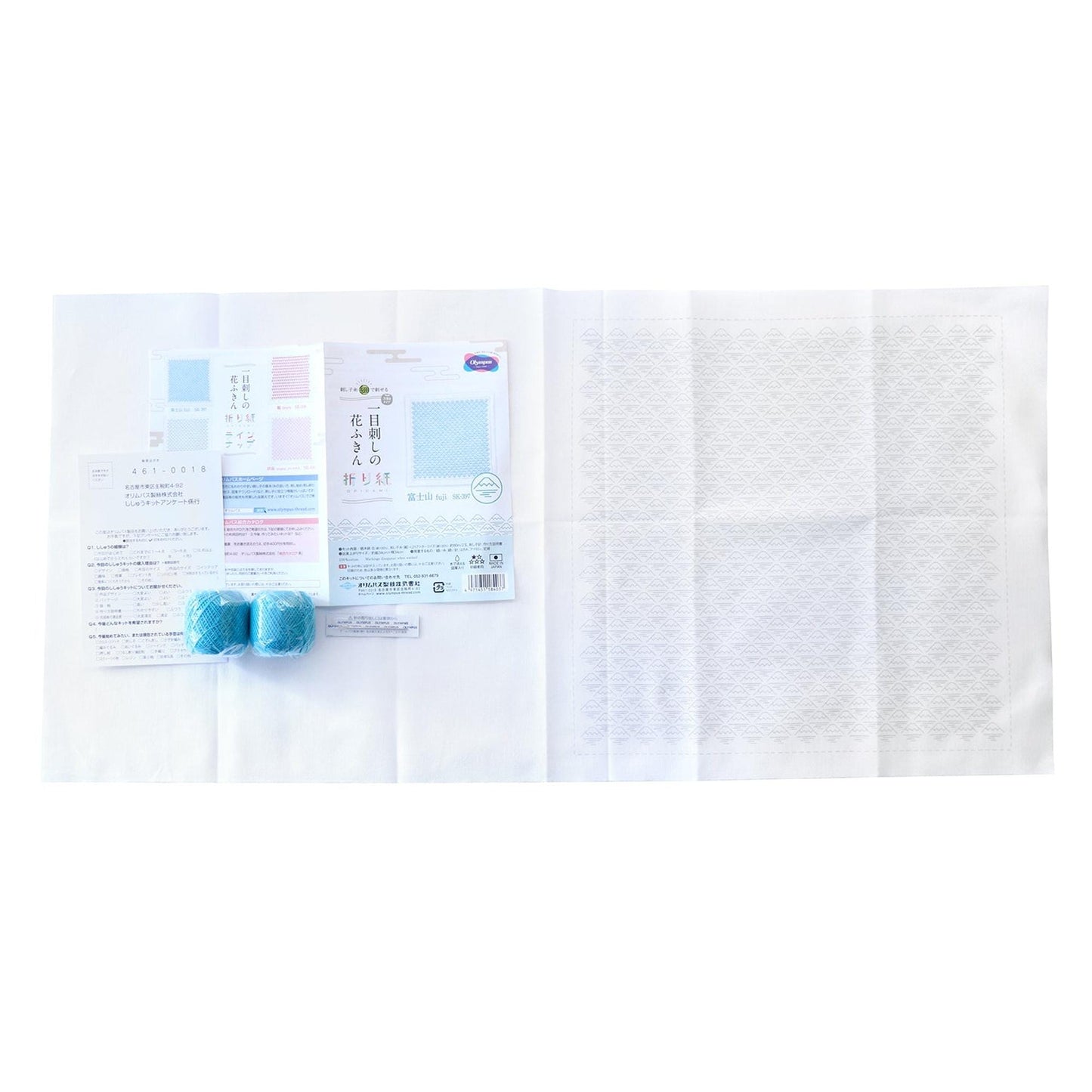various items, including a white paper, a blue object, and some text, all placed on a white surface.
