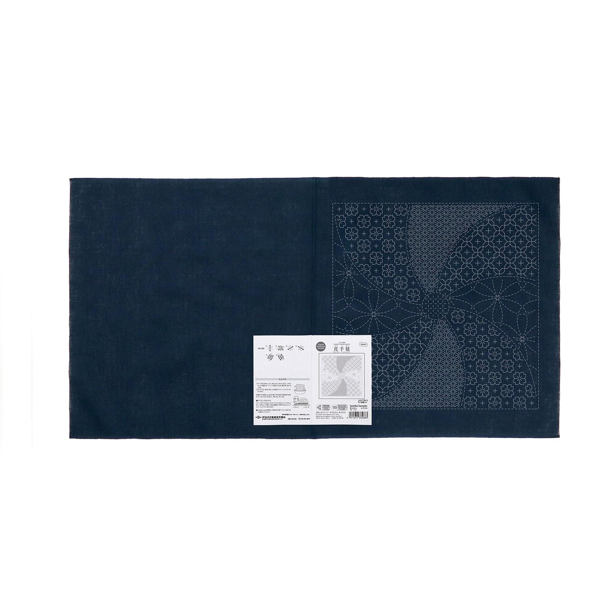The image is a dark blue fabric with a white label attached to it, which appears to be a sewing or crafting material.