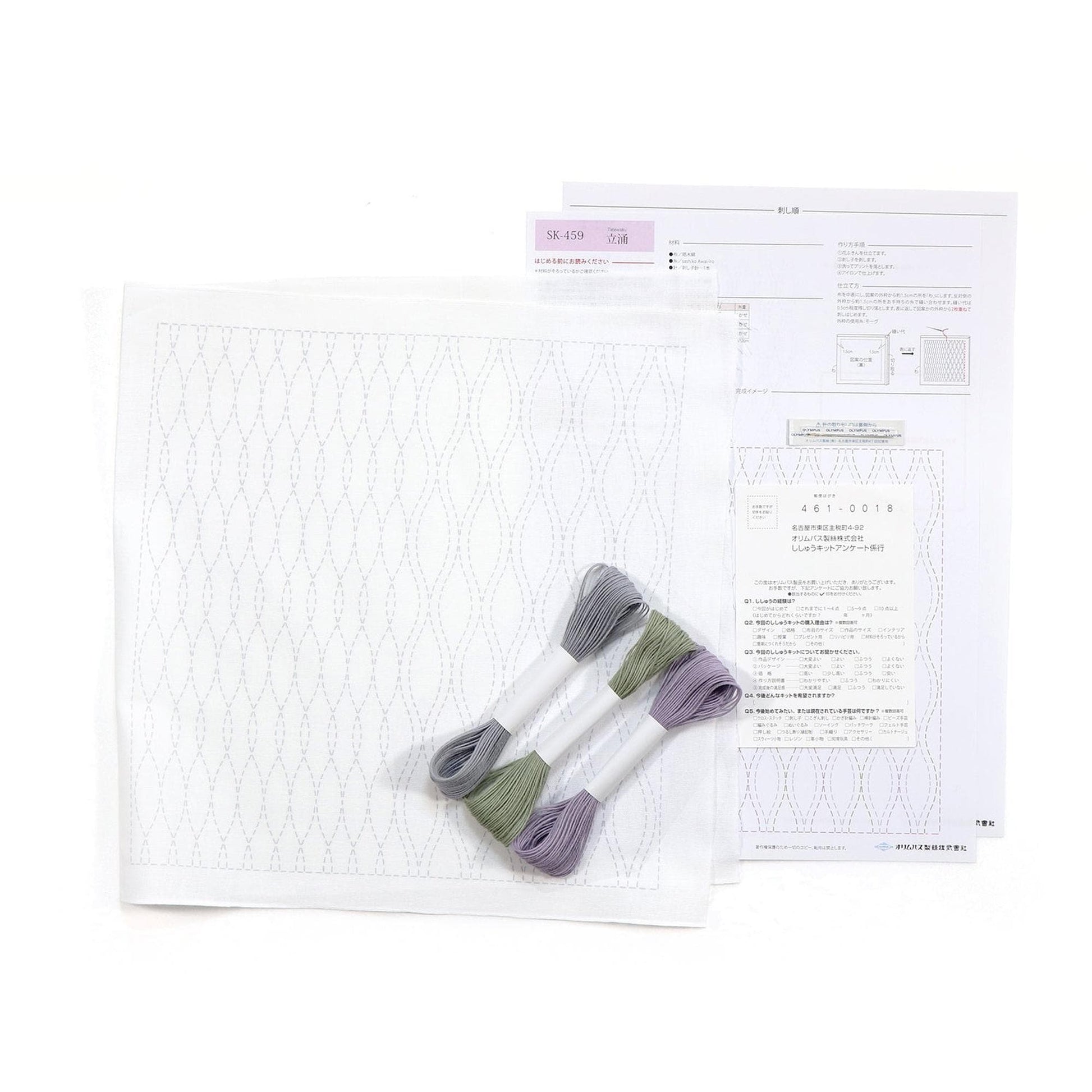 a sewing kit with a white fabric, two spools of thread, and some instructions or information related to the kit.