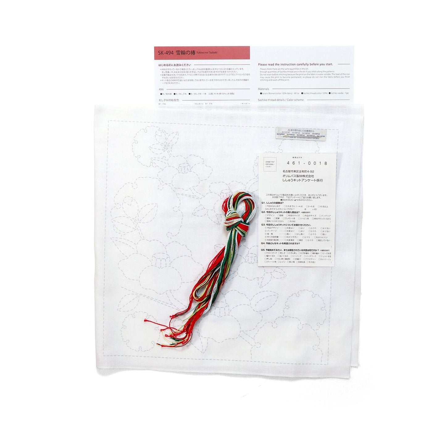 a sewing kit with instructions and a pattern, along with a spool of thread and a piece of paper with text.