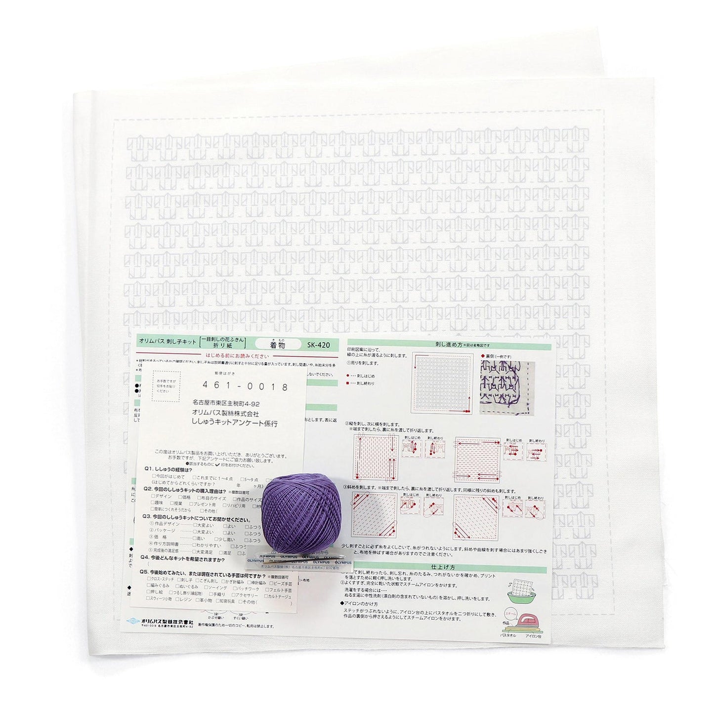 a white paper with Japanese text and a purple ball of yarn placed on top of it.