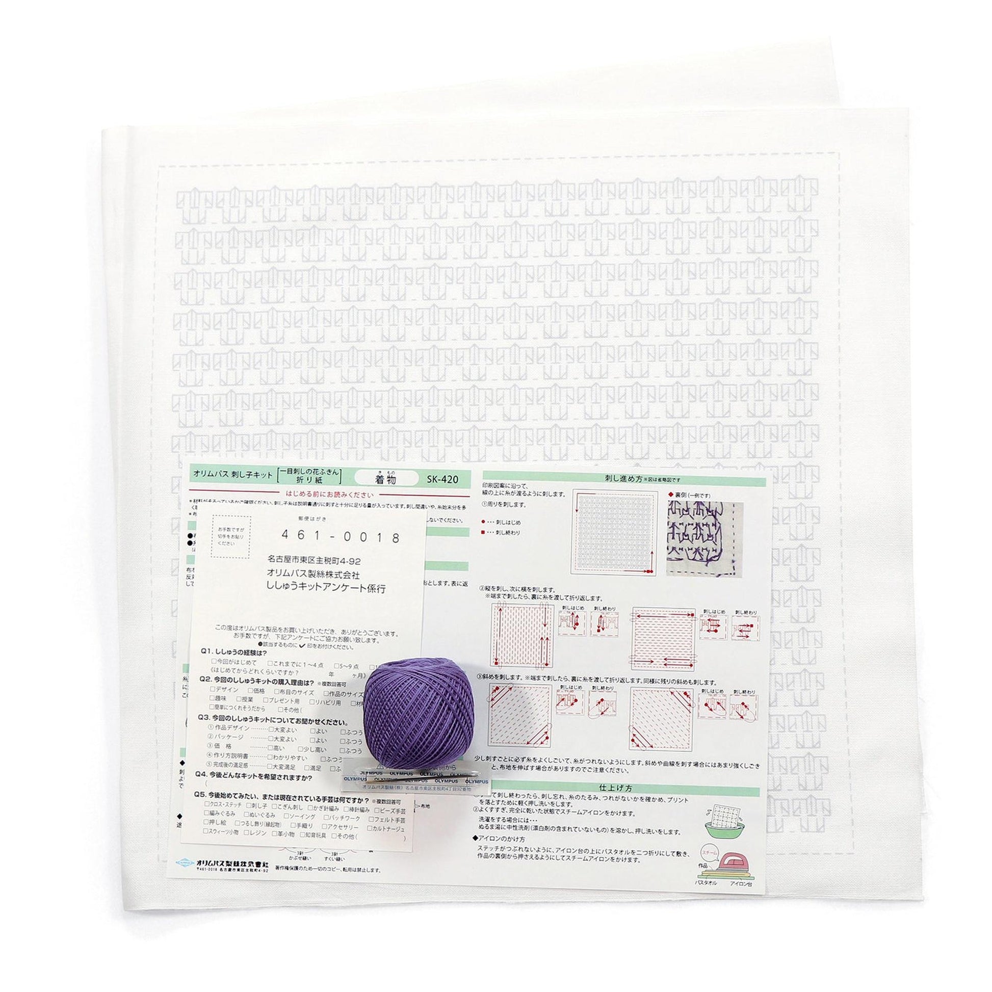 a white paper with Japanese text and a purple ball of yarn placed on top of it.