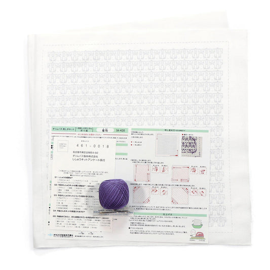 a white paper with Japanese text and a purple ball of yarn placed on top of it.