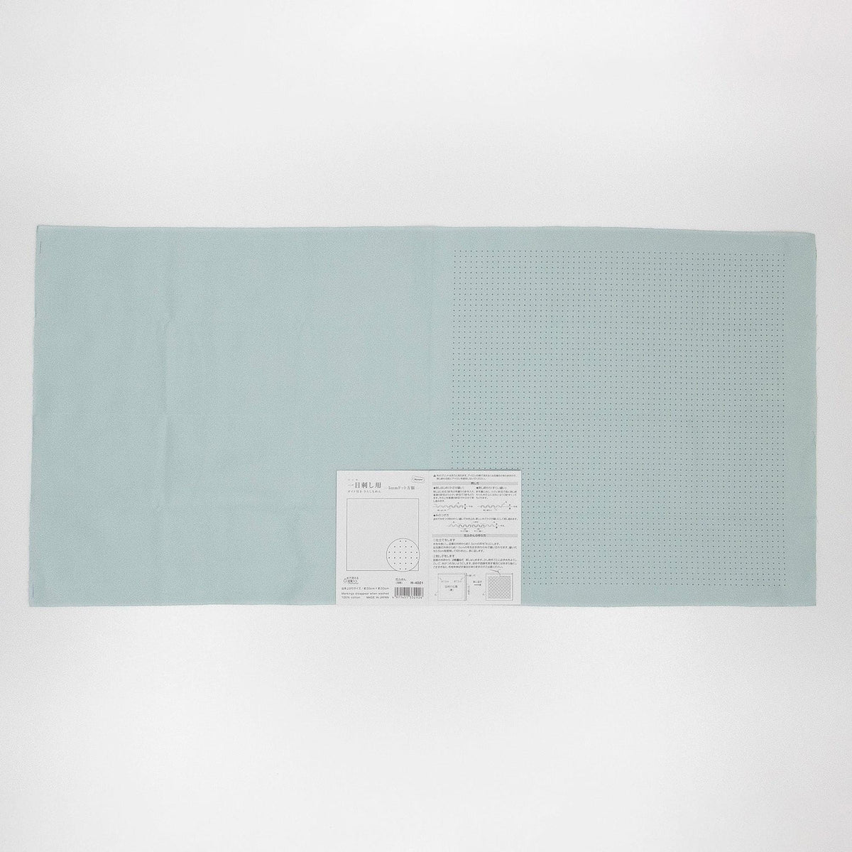 The image is a light blue rectangular piece of paper with a small white label attached to it.