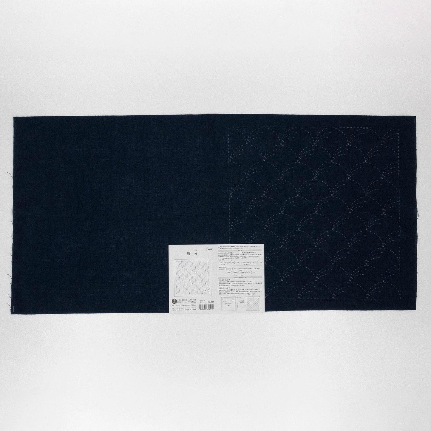 The image is a black fabric with a white label attached to it, which appears to be a sewing pattern or instructions.