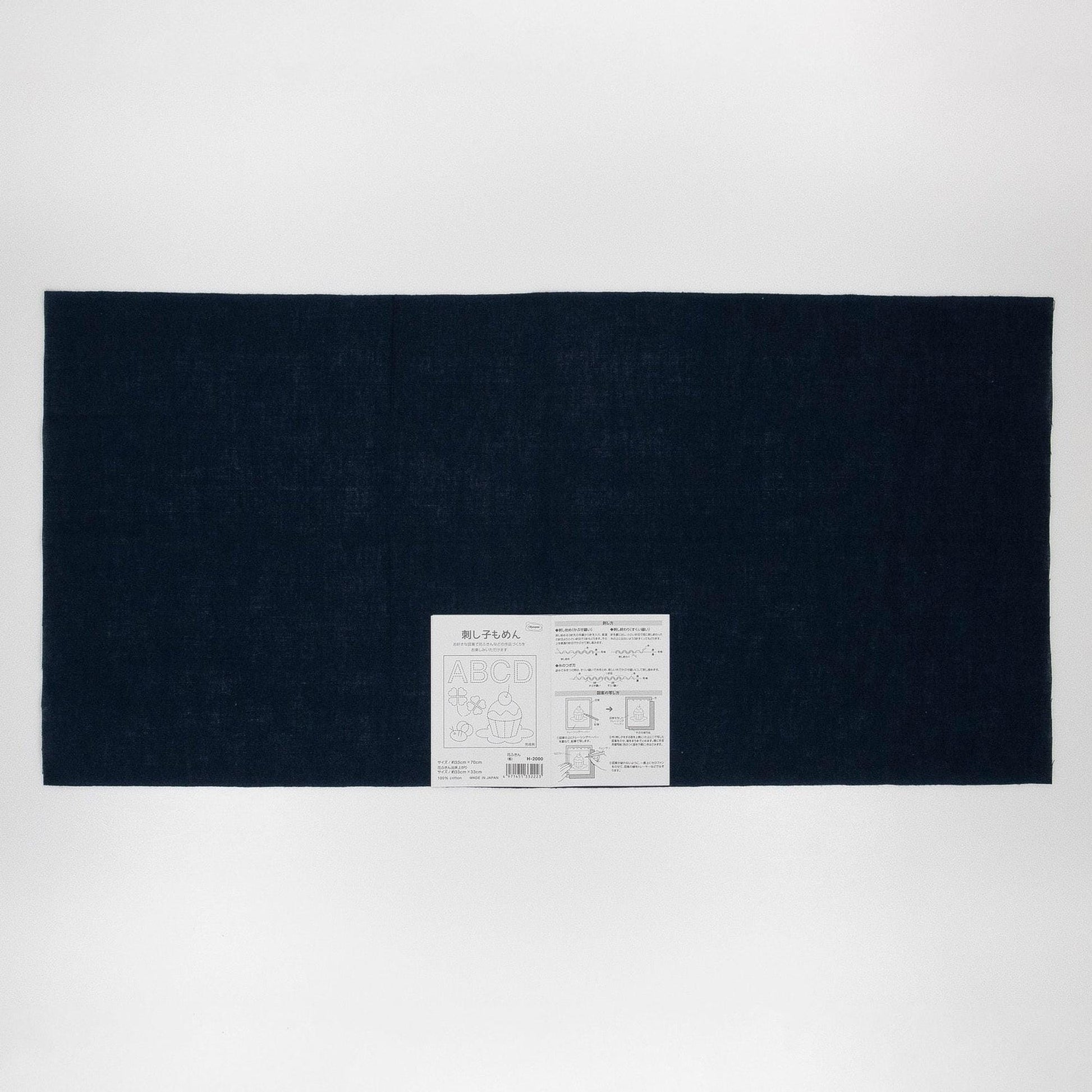 The image is a black rectangular fabric with a white label in the center, which appears to be a product label or instructions.