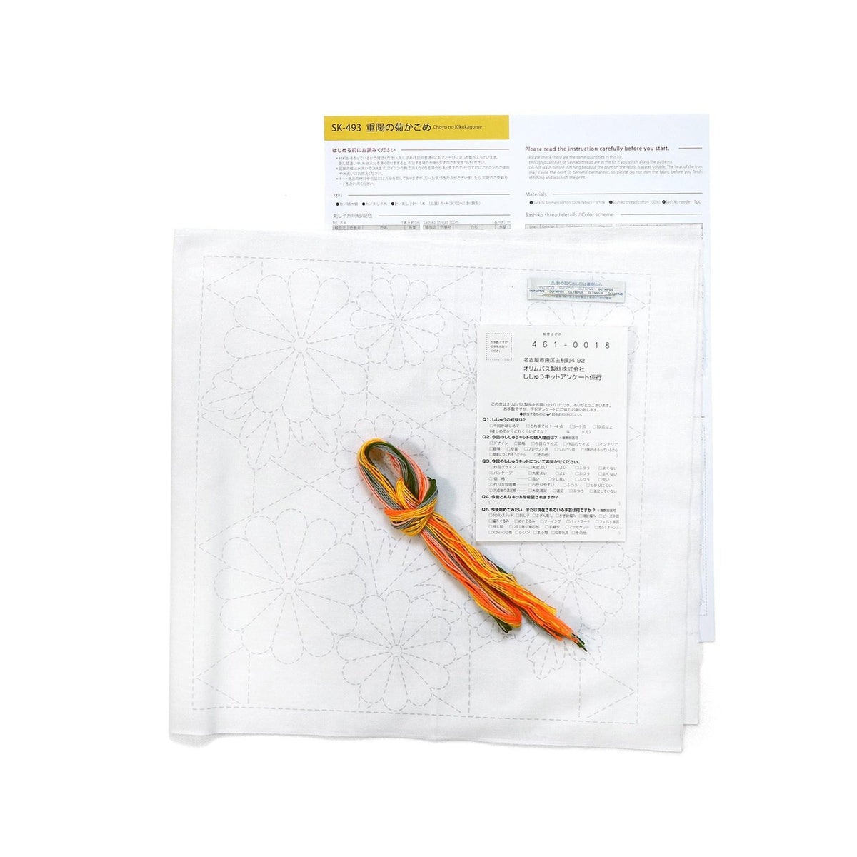 a sewing kit with a white paper sheet and a piece of fabric with a pattern on it. There is also a piece of paper with instructions and a price tag.