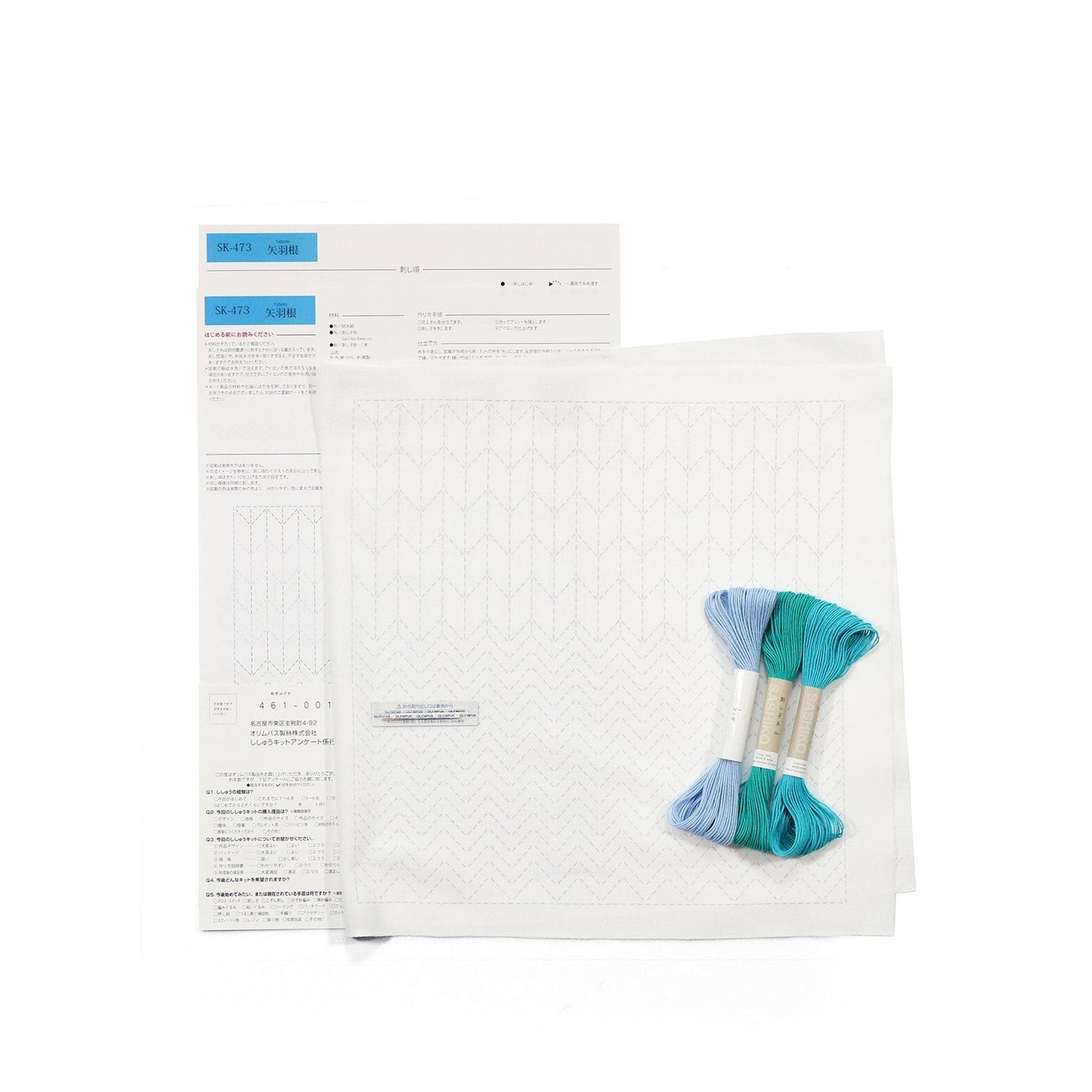a sewing kit with a pattern, a piece of paper with instructions, and some thread in blue and green colors.