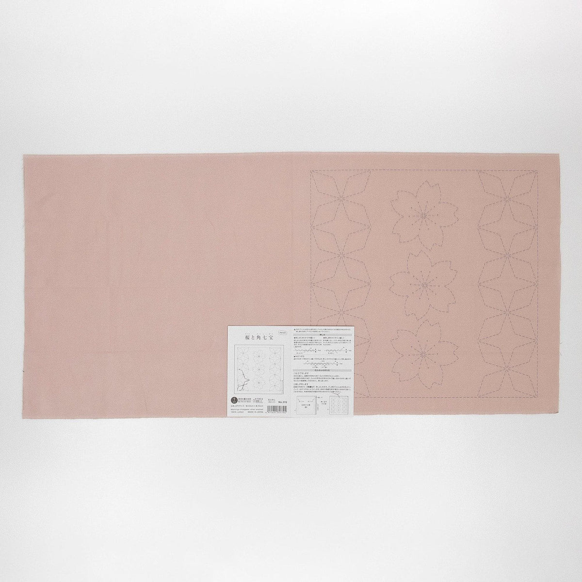 The image is a pink fabric with a white label attached to it, which appears to be a sewing pattern or instructions.