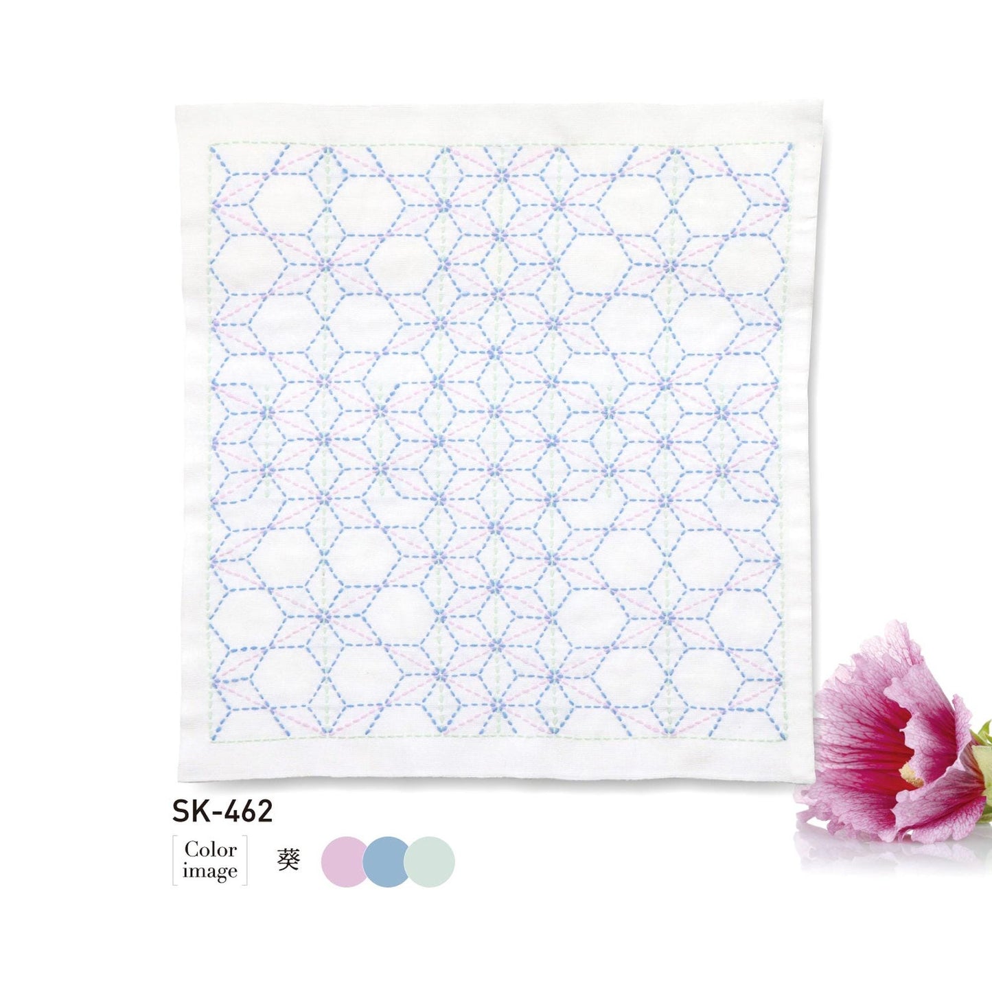 a square piece of fabric with a geometric pattern of hexagons and circles, and it is accompanied by a single pink flower.