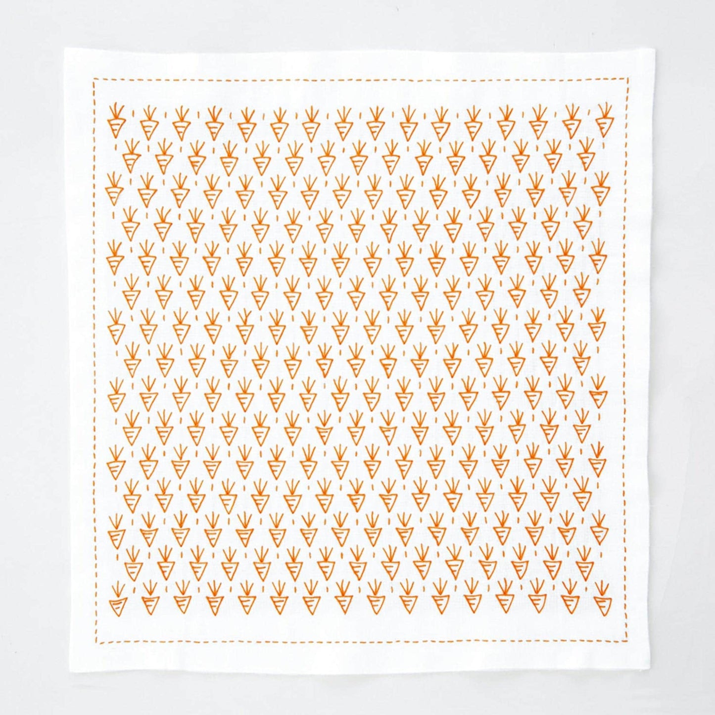 a square-shaped white cloth with a repeating pattern of orange triangles.