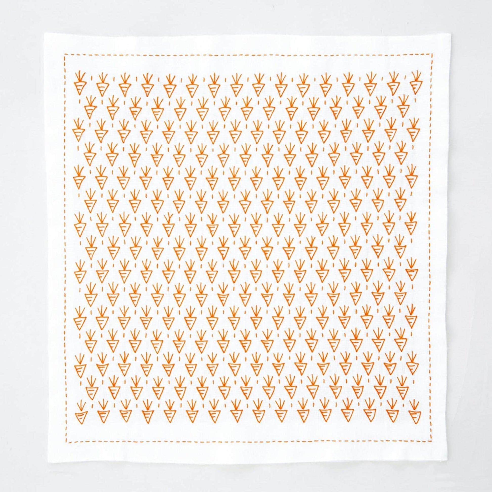 a square-shaped white cloth with a repeating pattern of orange triangles.
