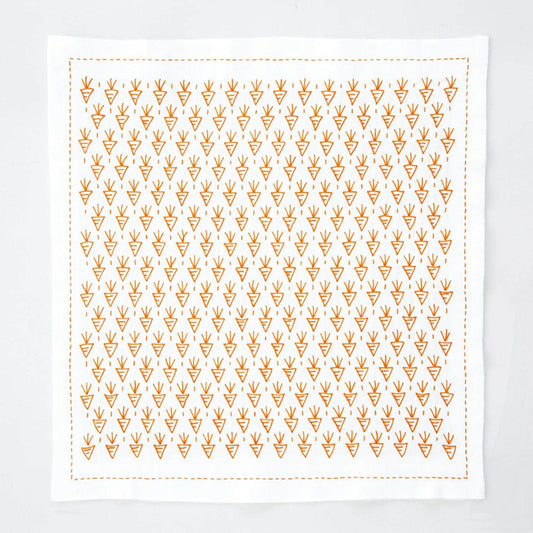 a square-shaped white cloth with a repeating pattern of orange triangles.