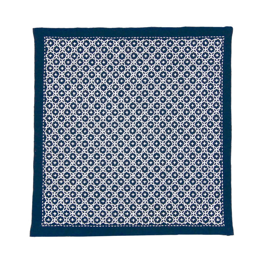 a square-shaped fabric with a repeating pattern of white and navy blue geometric shapes.