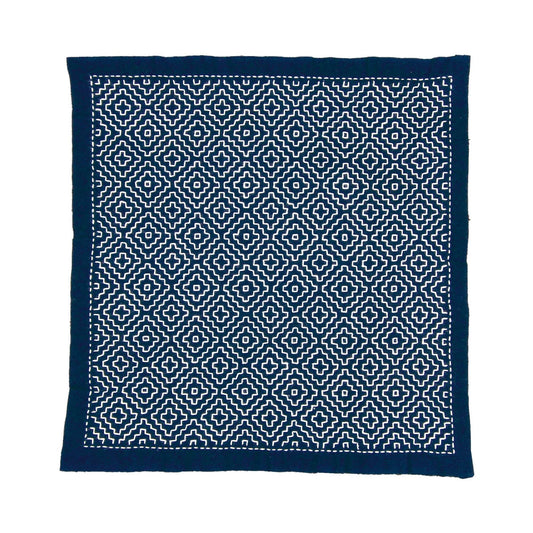 a square-shaped fabric with a repeating pattern of white and navy blue geometric shapes, creating a visually striking and intricate design.