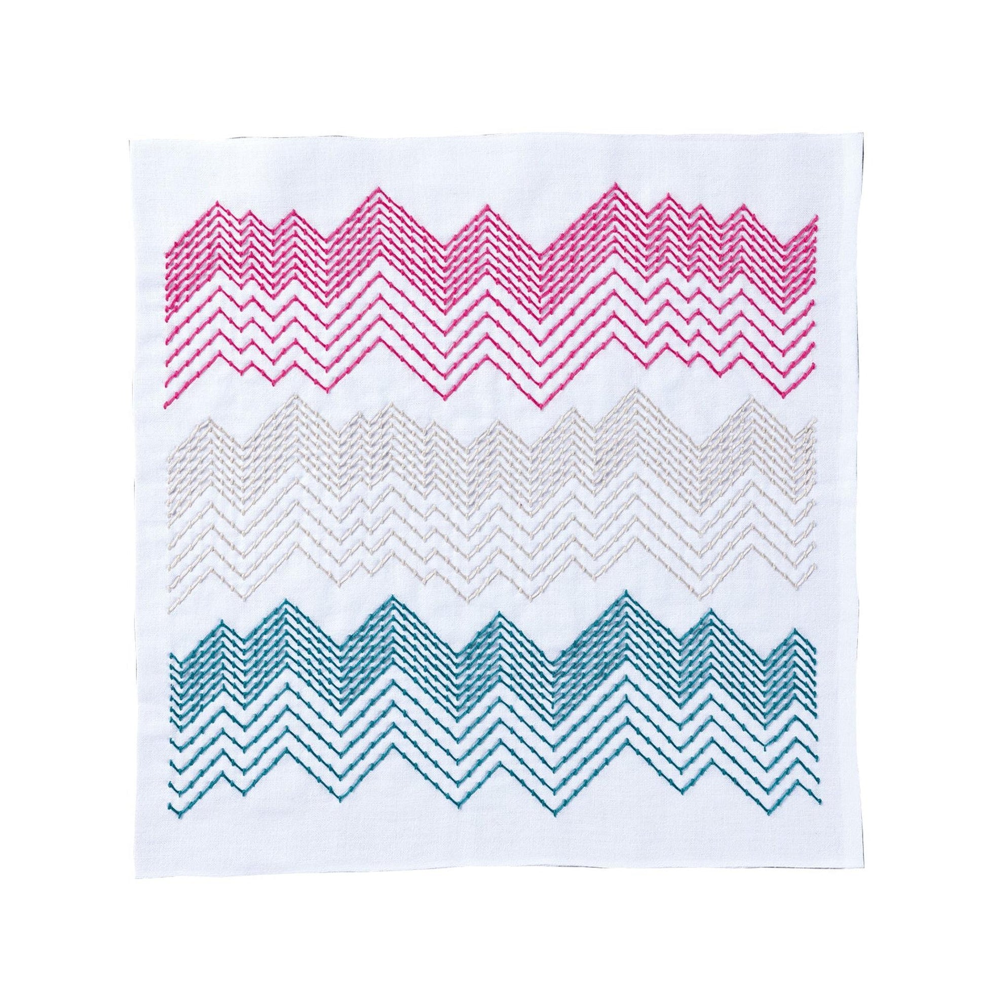 a square with a zigzag pattern in pink, blue, and green colors.