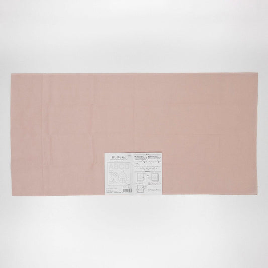 The image is a plain, light pink fabric or paper with a small label or text on it.