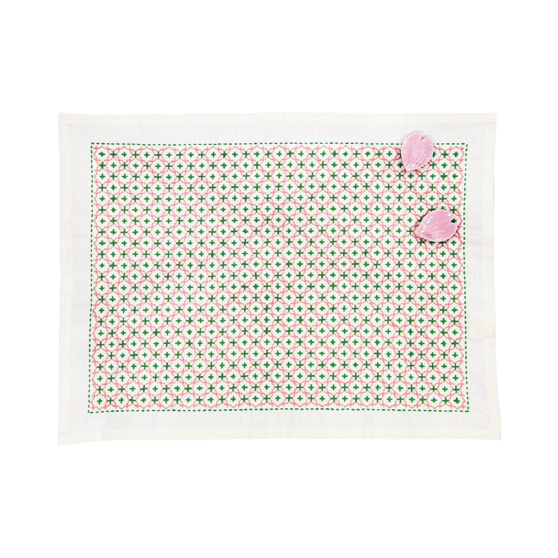 a square-shaped placemat with a green and white geometric pattern.