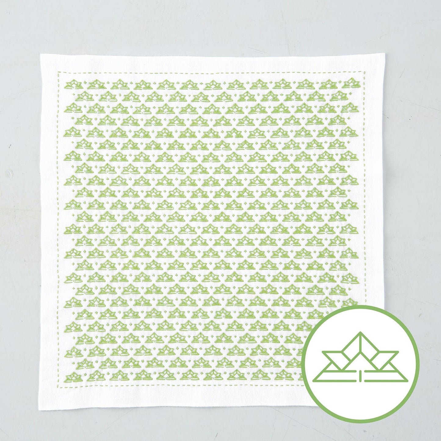 a square piece of fabric with a repeating pattern of green triangles.