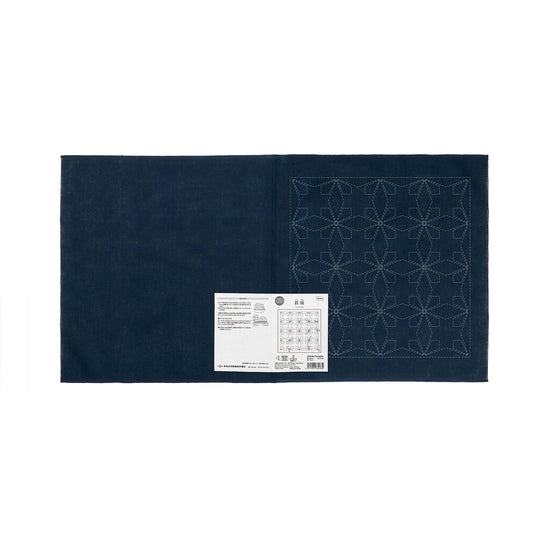a dark blue fabric with a white label attached to it, displaying a pattern or instructions.